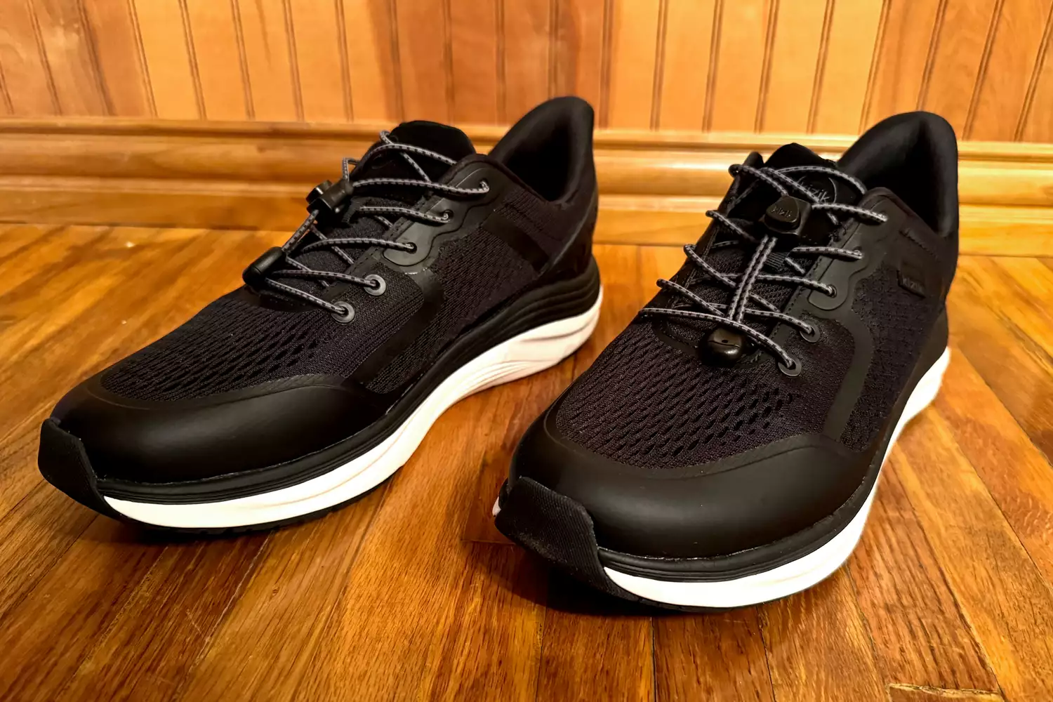 The side view of the Kizik Men's London Sneakers on wood