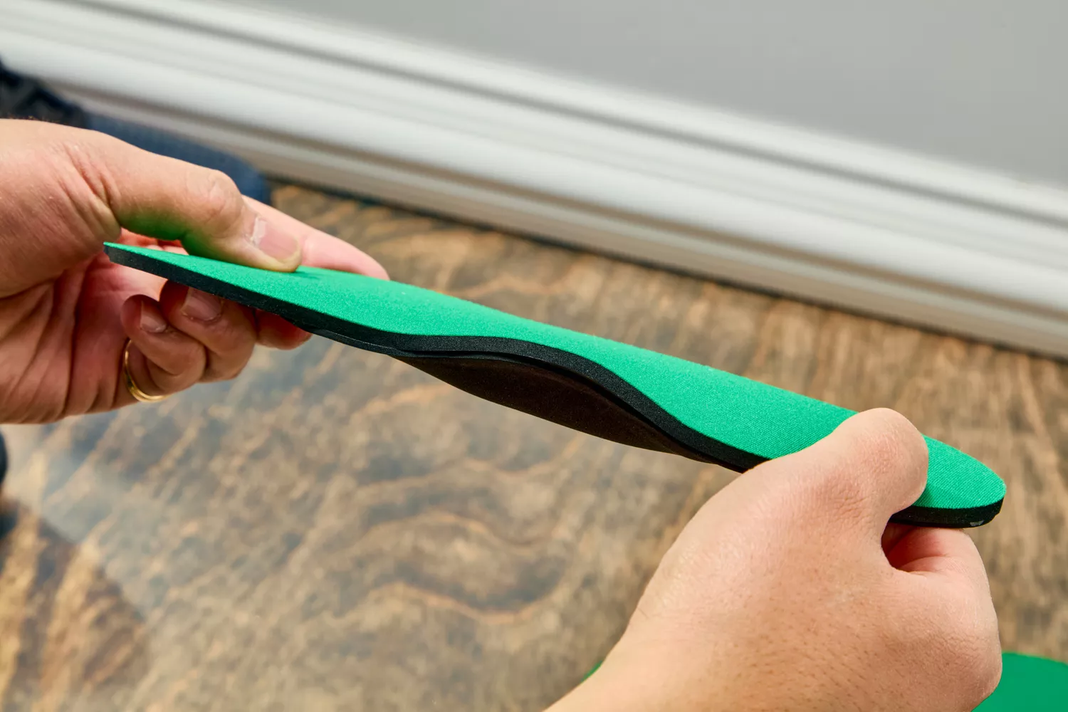 Hands holding a Spenco RX Comfort Insole