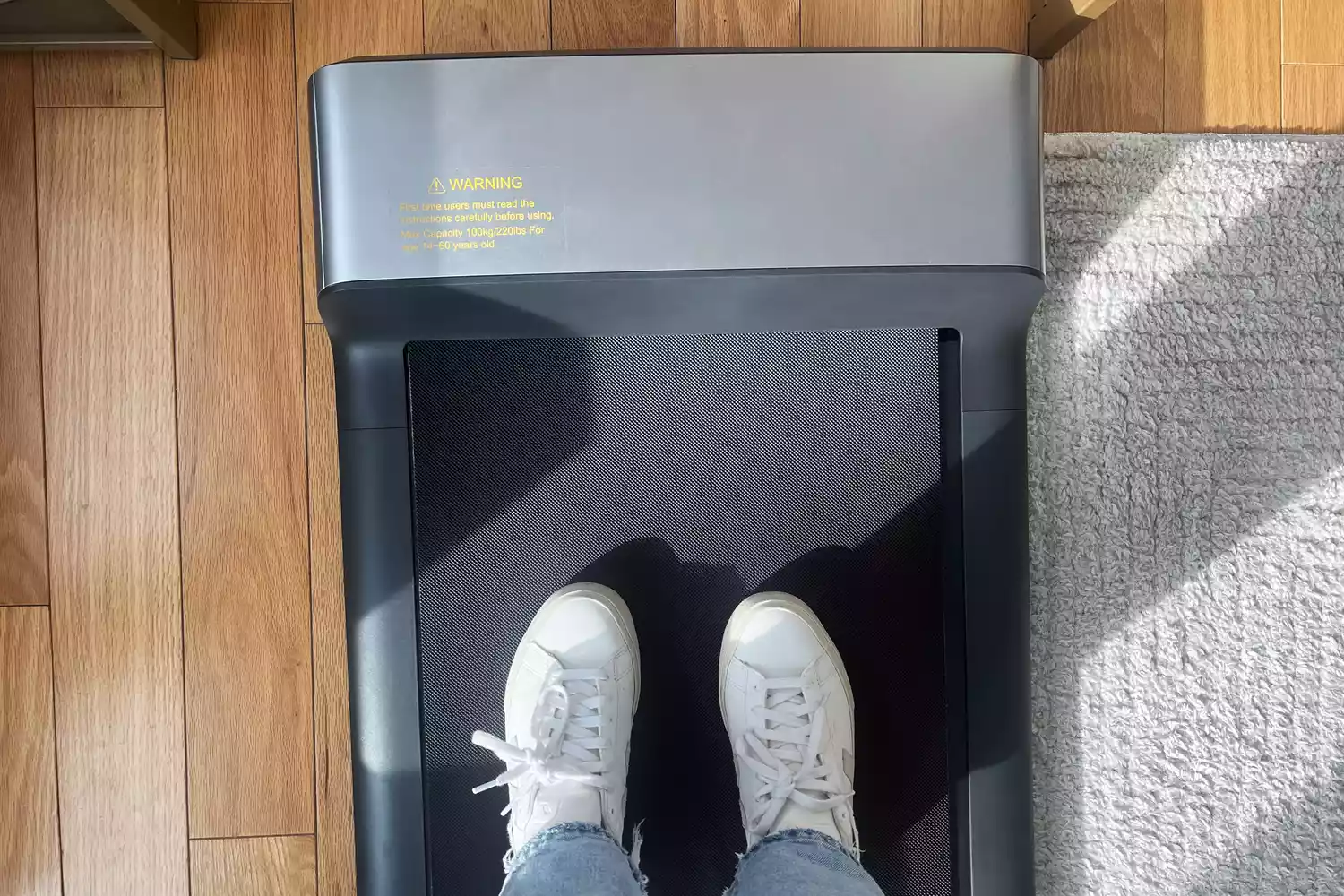Feet in walking shoes standing on WalkingPad P1 Foldable Walking Treadmill