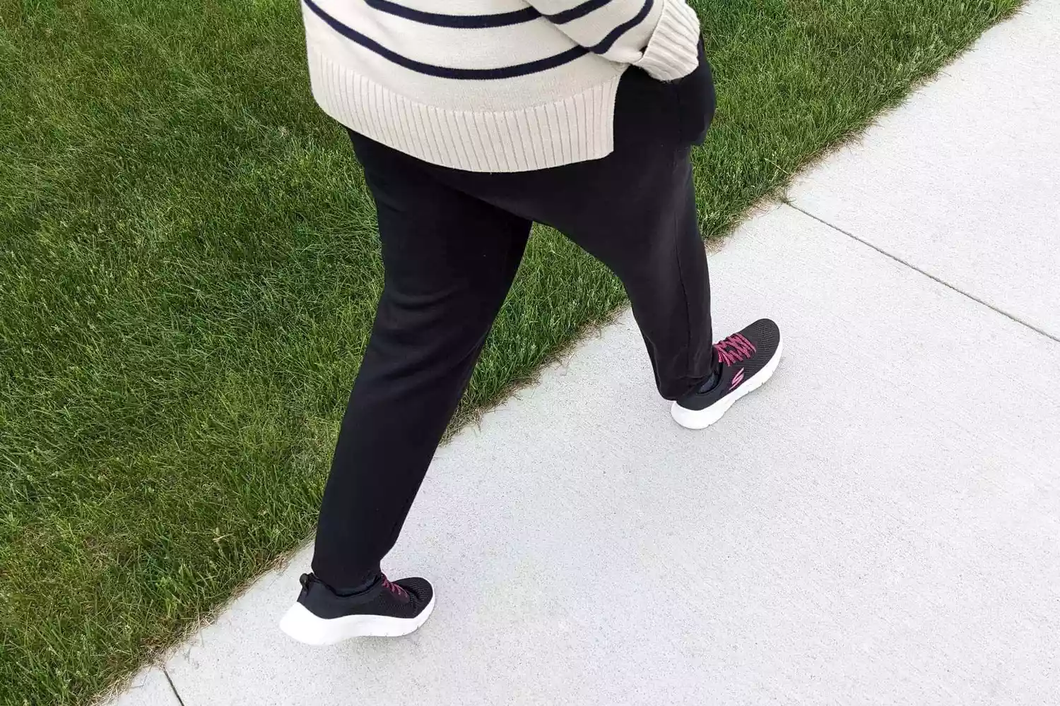 Person wearing Skechers Go Walk Flex Alani Walking Shoes while walking on sidewalk