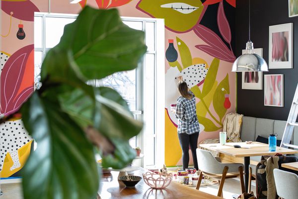 Woman painting a mural in her home