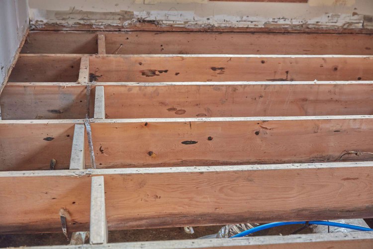 Wooden beams horizontally laid for foundation of renovated house