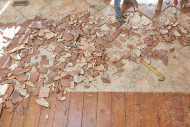 Tile flooring demolished next to wooden flooring for house renovation