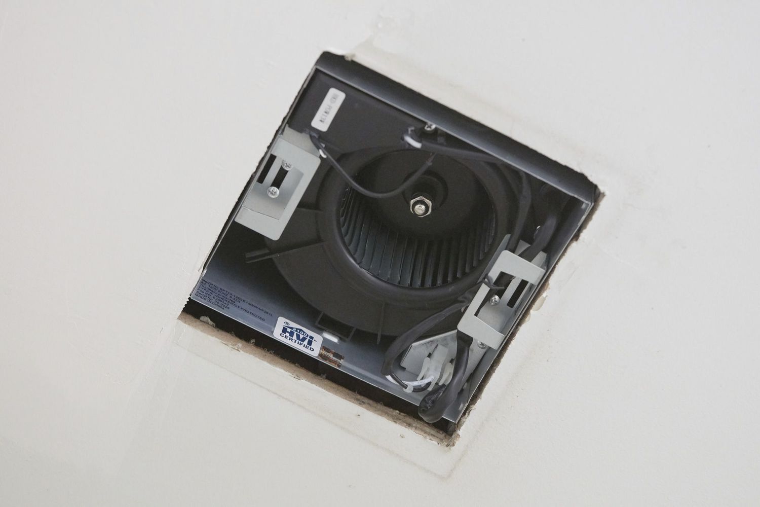 Bathroom exhaust fan exposed in ceiling hole