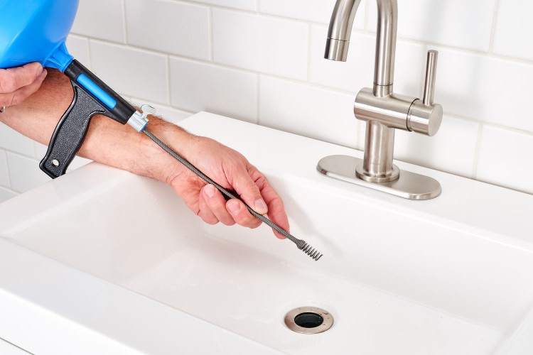 Auger cable inserted into sink drain opening