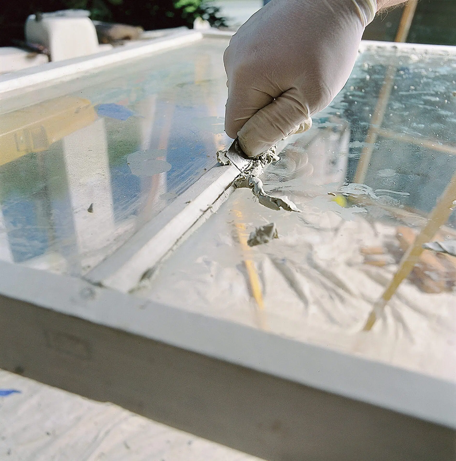 A man preparing a window to have sashes applied to it.