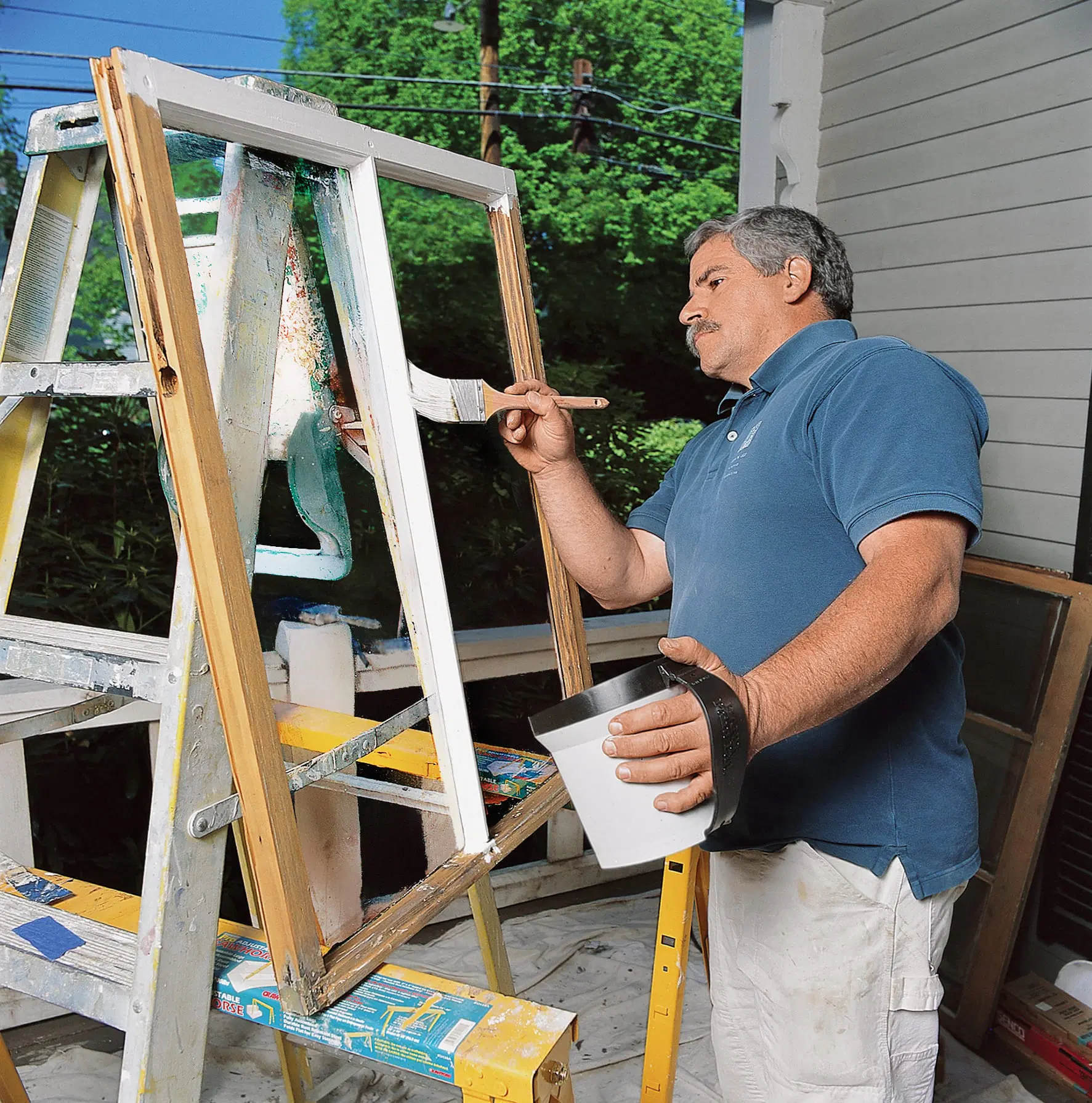 A main painting a window frame in preparation of installing sashes.