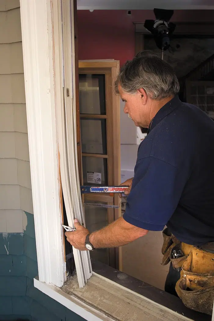 Tom Silva pries off the jamb liners to replace old windows.