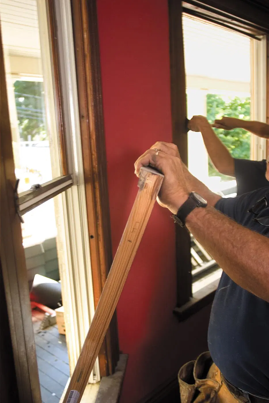 A man takes out the old sash to replace windows.