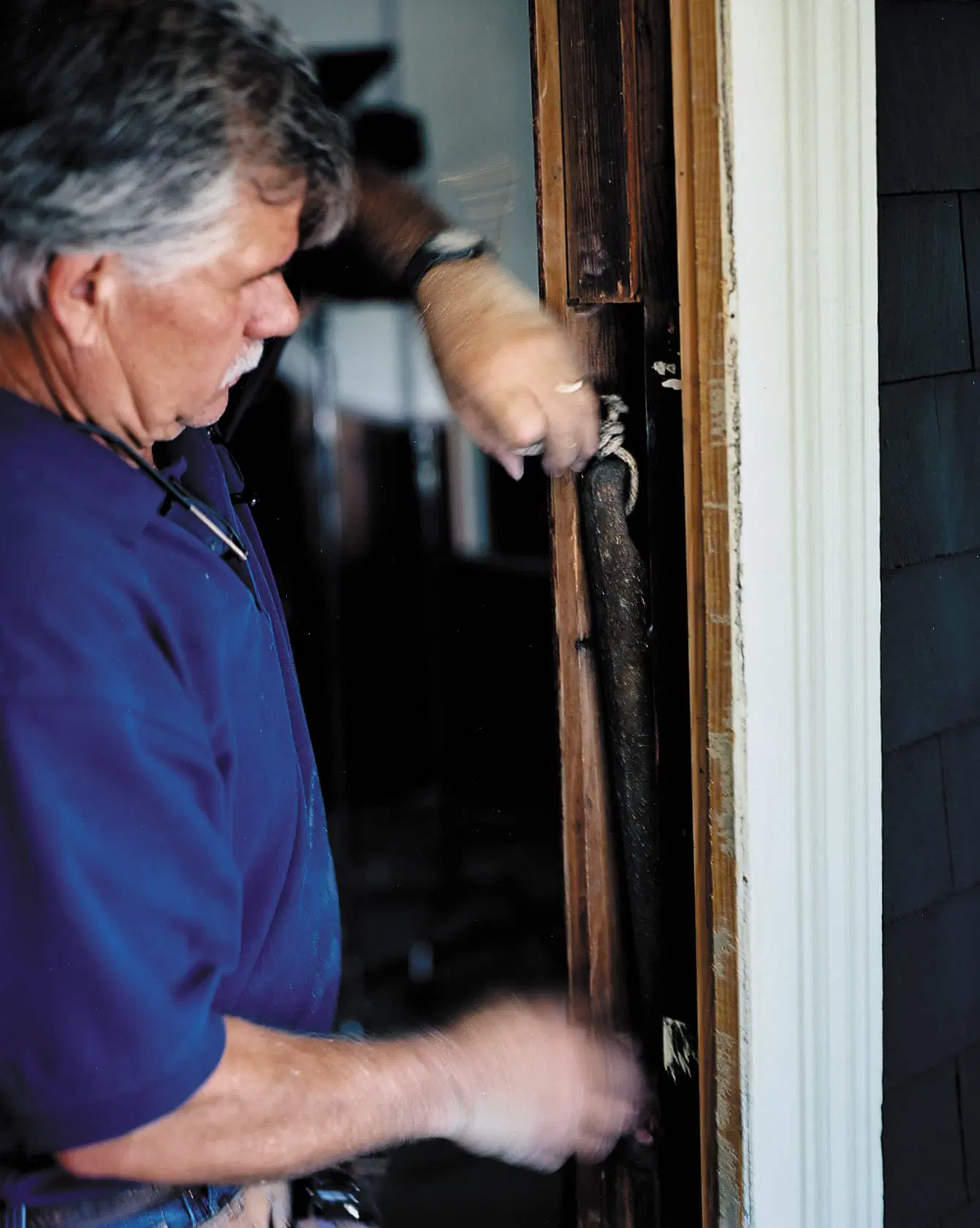 Tom Silva removes old sash weights before replacing the window.