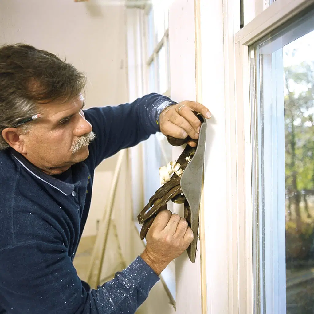 Tom Silva prepares the jambs to trim the window.