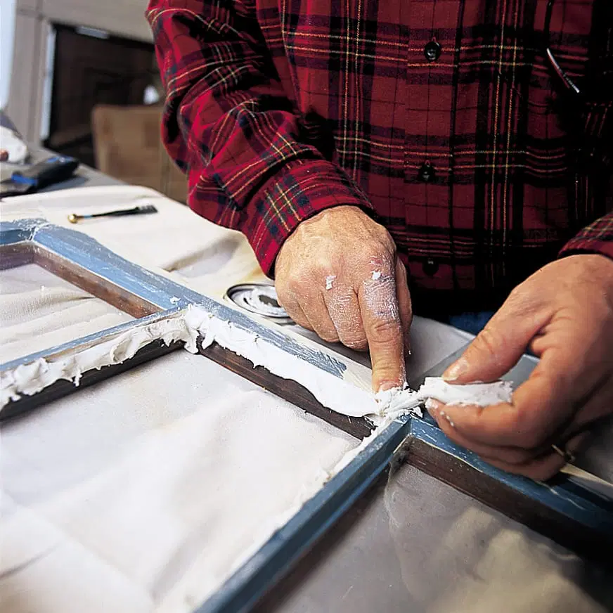 Metal glazing being removed from the rabbets of a window pane.
