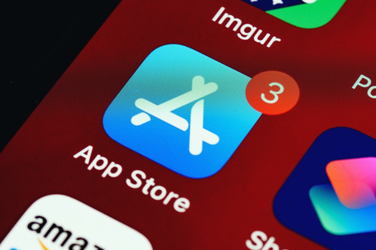 A photo of an Apple screen and a close-up of the App Store icon with three notifications on it.