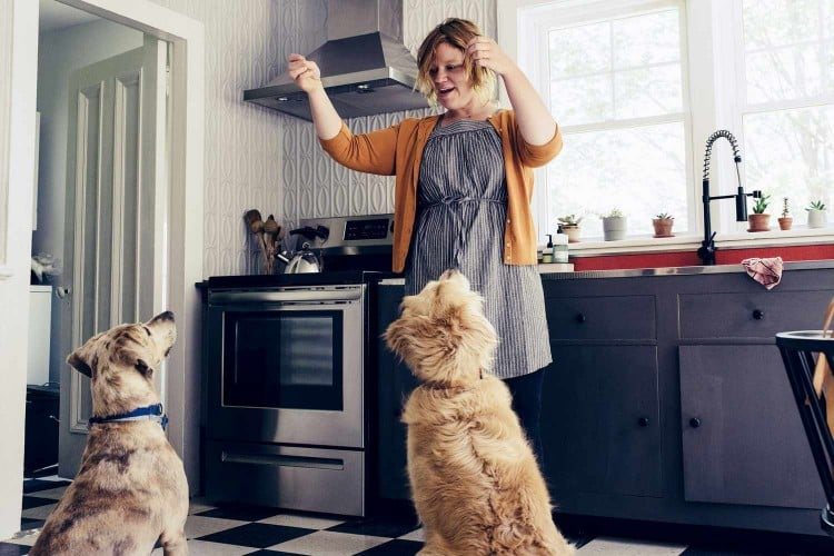 woman giving treats to two dogs