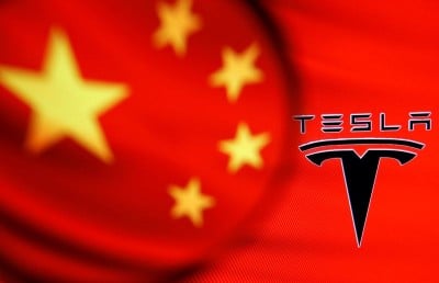 &copy; Reuters. Chinese flag and Tesla logo is seen through a magnifier in this illustration taken January 7, 2021. REUTERS/Dado Ruvic/Illustration/file photo