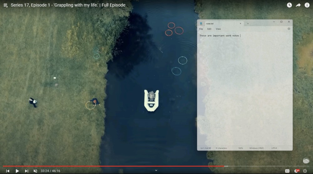 An overhead view of a gorilla in a boat on an English river is shown—a clip from the current season of Taskmaster. A transparent Notepad window, shown over it, says "These are important work notes." 