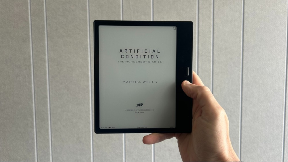 Holding up the Boox Go 7 in one hand with an e-book open on the screen