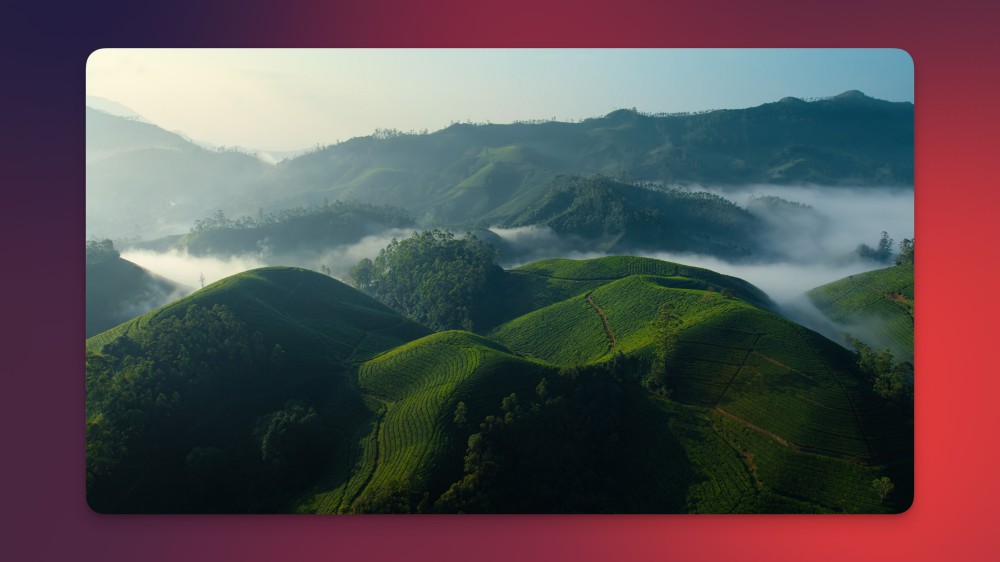 Apple TV's new India screensaver showing green hills among the clouds.