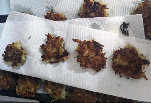 crispy latkes draining on paper towels. 