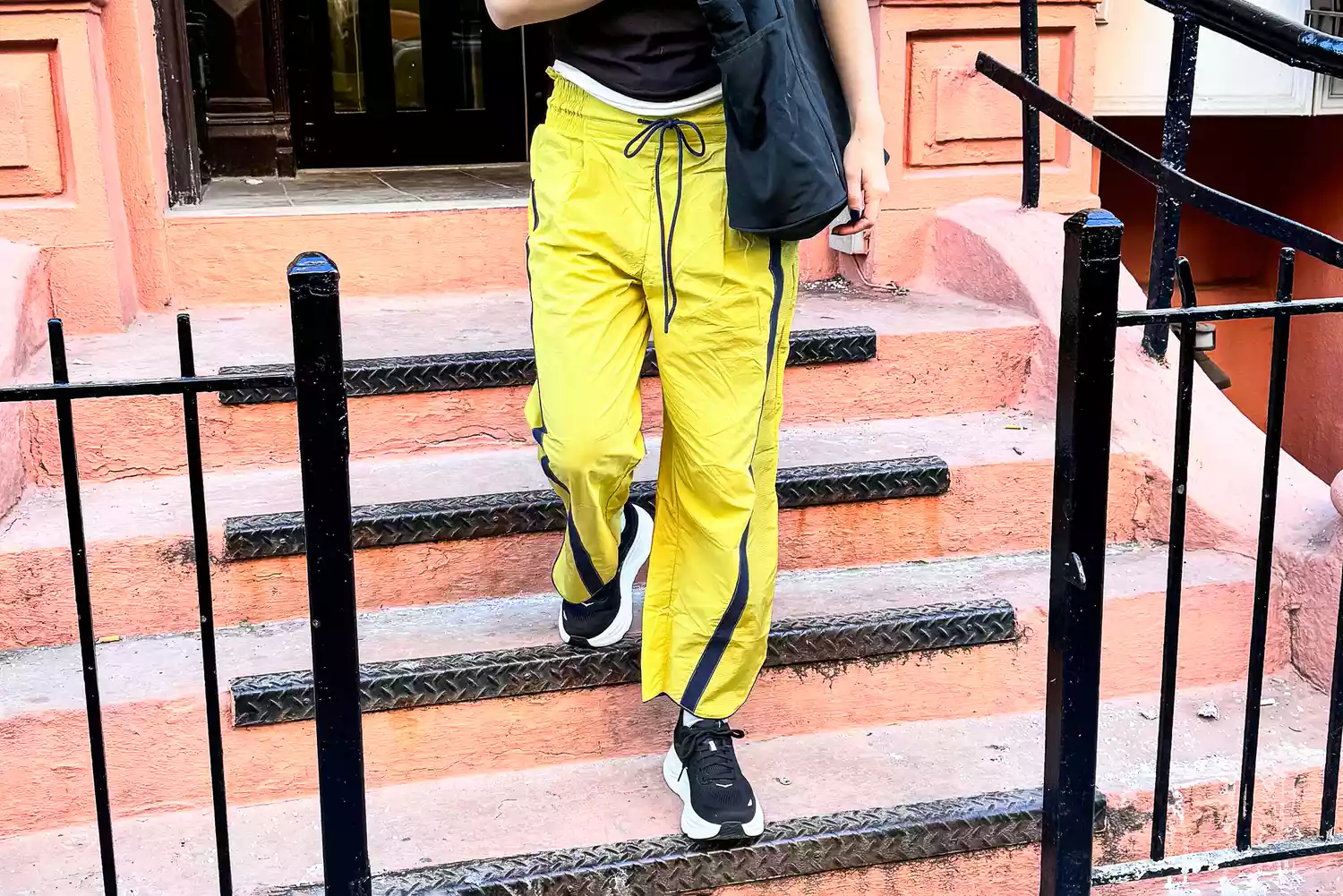 Close-up of a woman's legs and feet wearing Hoka Bondi 9 sneakers and Free People's Champ Is Here Pants