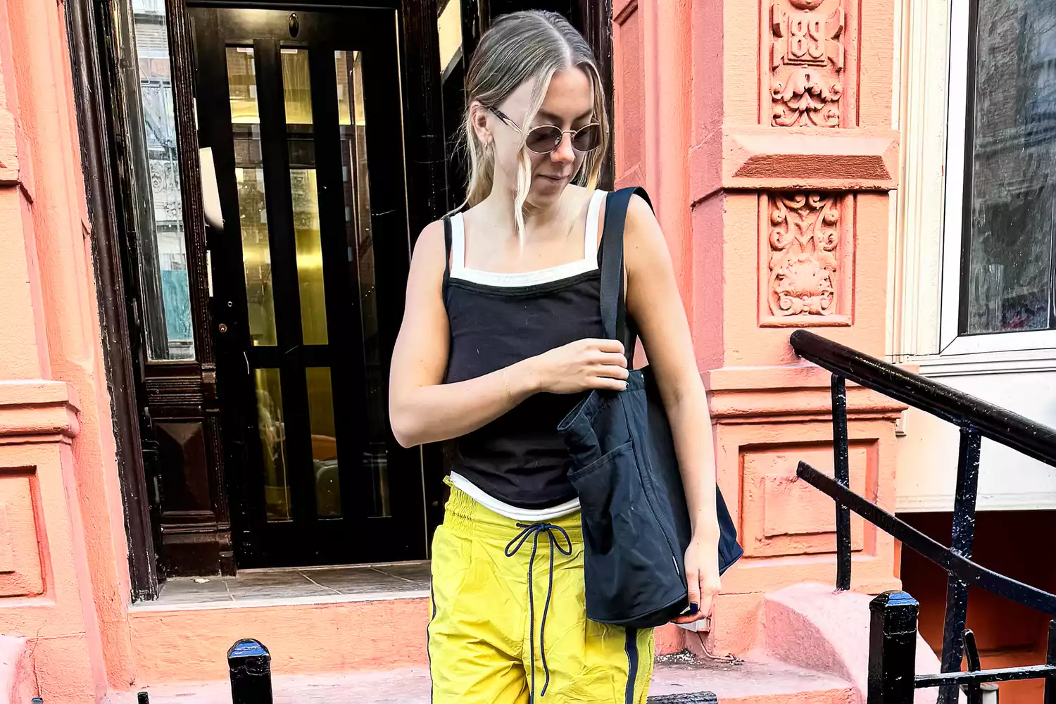 A woman wears Free People Champ Is Here Pants and Hoka Bondi 9 sneakers