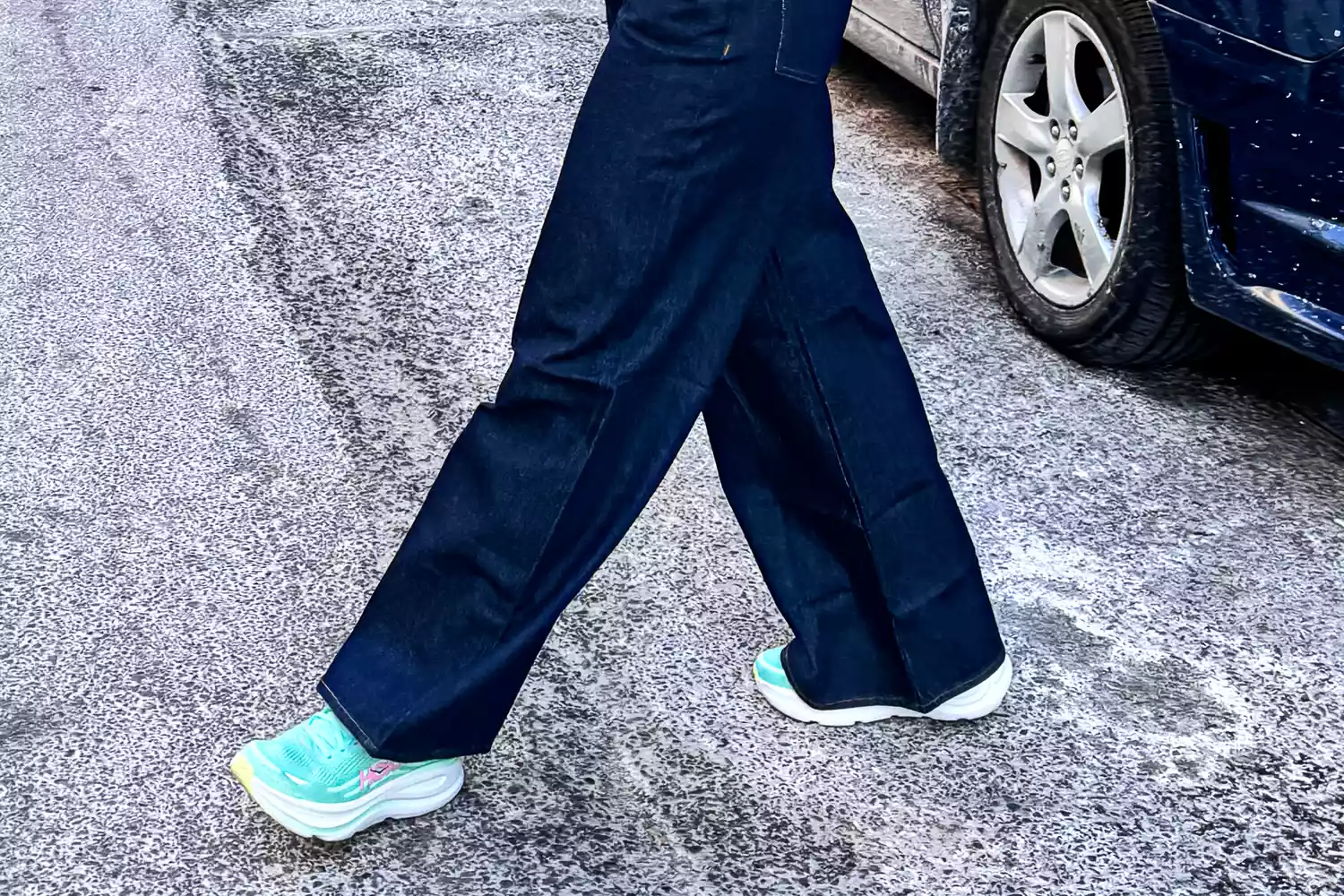 Close-up of a person's feet wearing Hoka Bondi 9 sneakers while walking on a city street