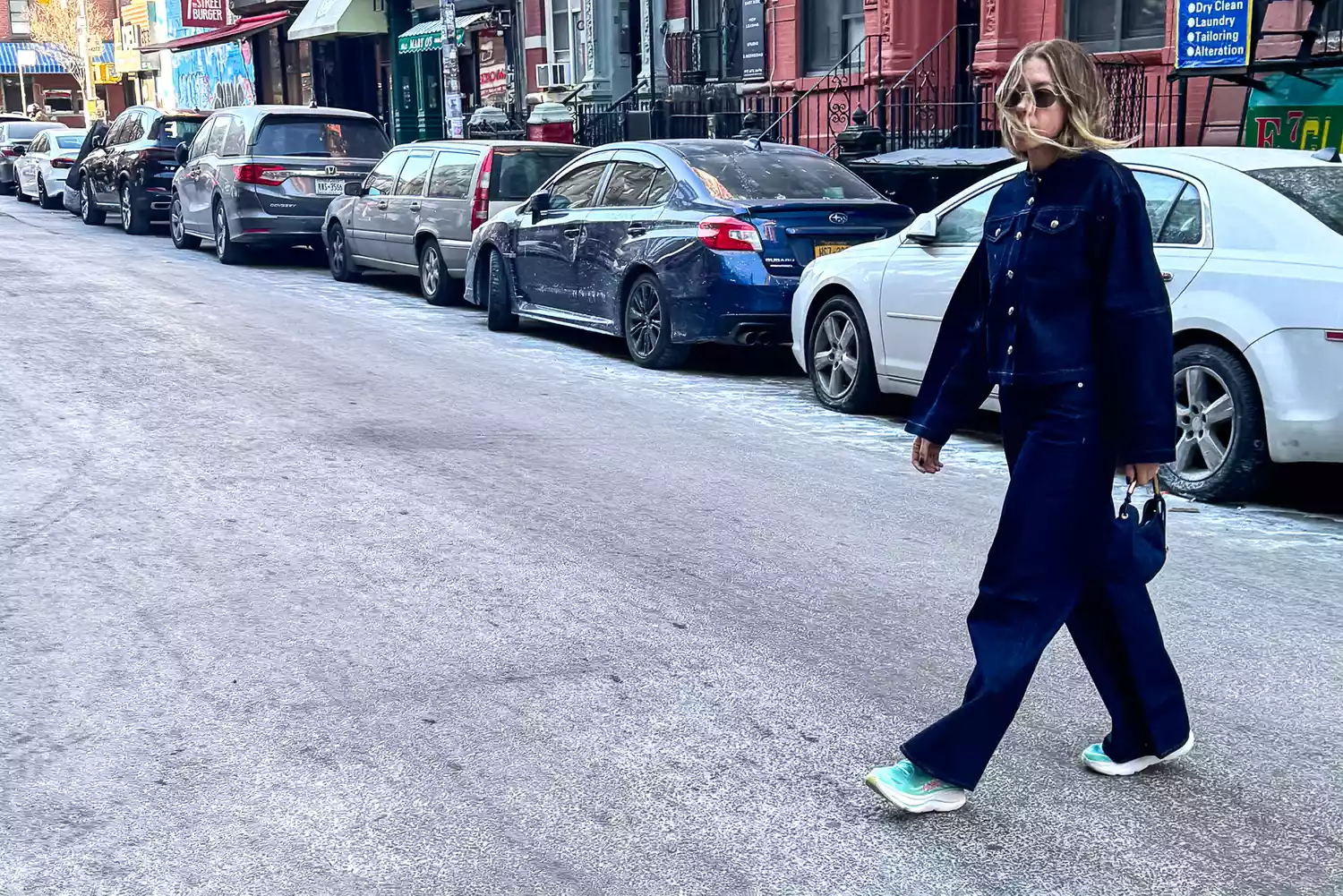 Woman wears Hoka Bondi 9 sneakers while walking on a city street
