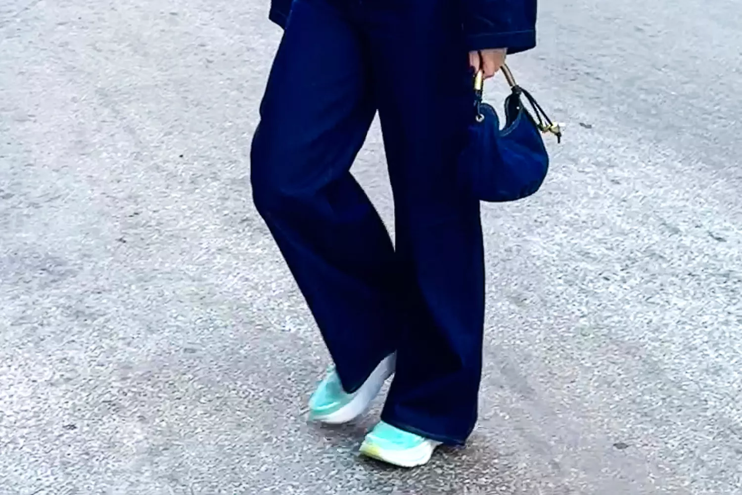 Close-up of a person's feet wearing Hoka Bondi 9 sneakers while standing on a city street
