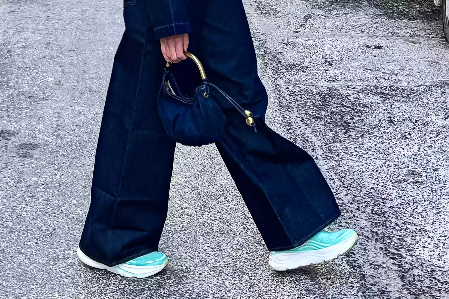 Close-up of a person's feet wearing Hoka Bondi 9 sneakers while walking on a city street