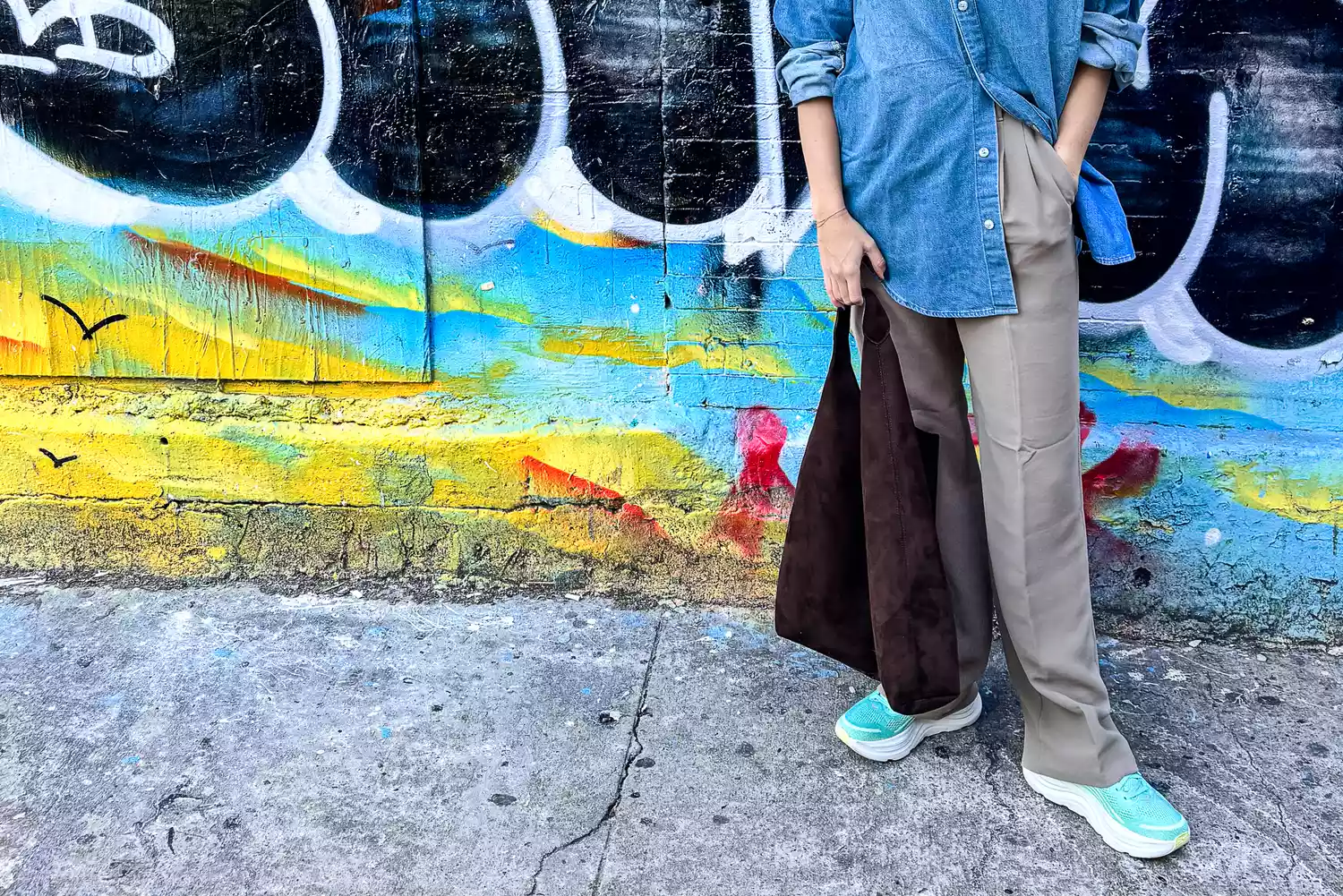 Close-up of a person's feet wearing Hoka Bondi 9 sneakers while standing on a city street