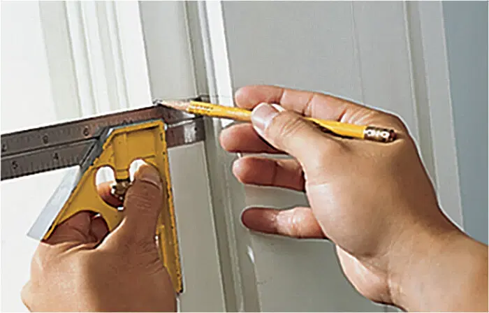 A pencil being used to mark the hinge locations for an internal shutter.