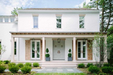 A cottage style home with a rock and concrete pathway