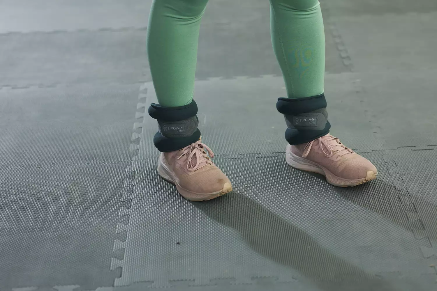 P Volve 3 LB Ankle Weights worn on ankles in a gym setting 