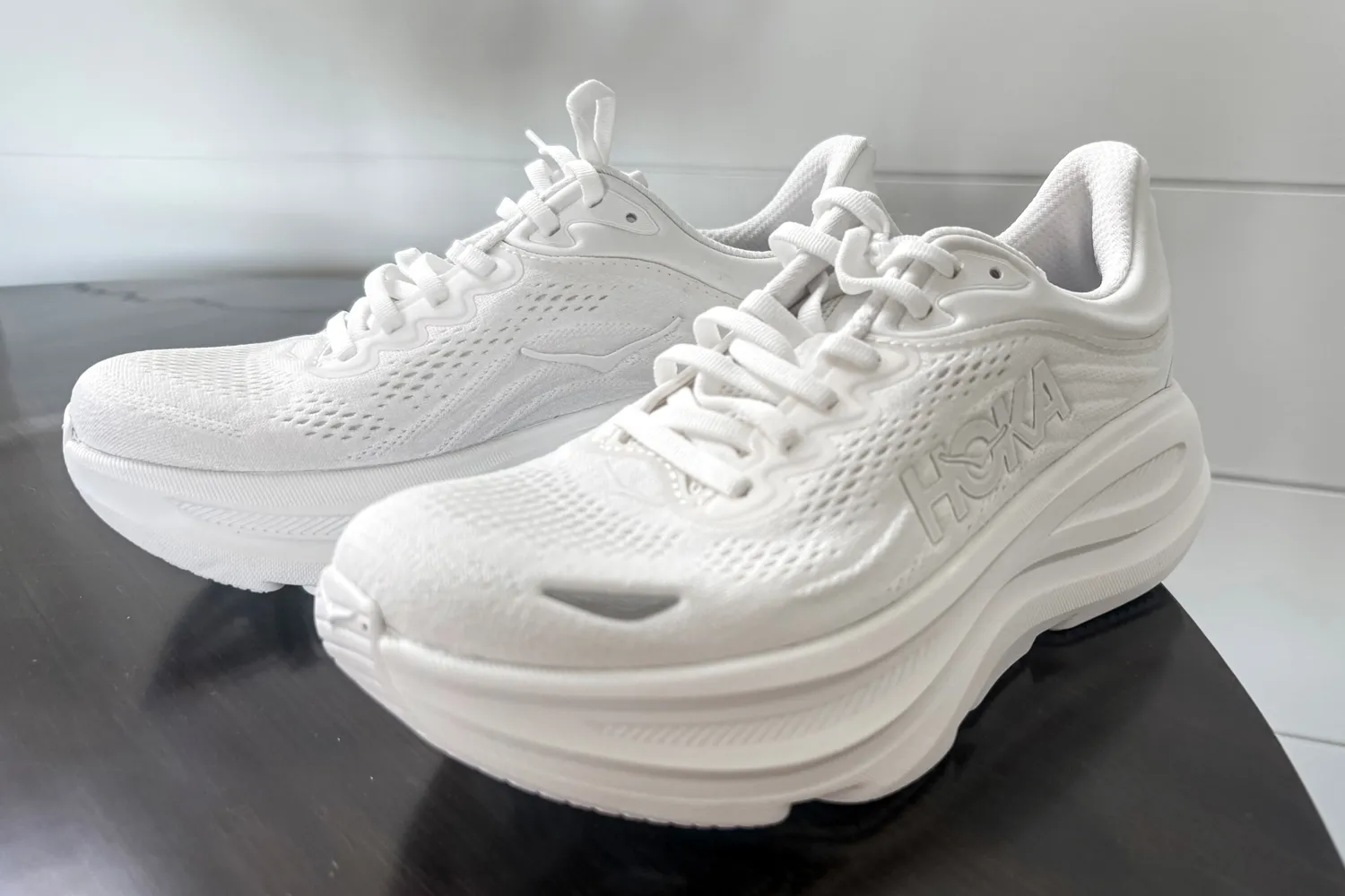 A pair of HOKA Men's Bondi 9 Running Shoes on a table
