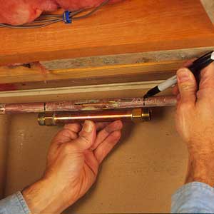 A compression repair coupling being held against a damaged pipe.