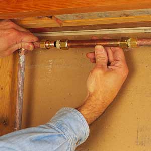 a repair coupling being slid into place between two ends of damaged pipe.