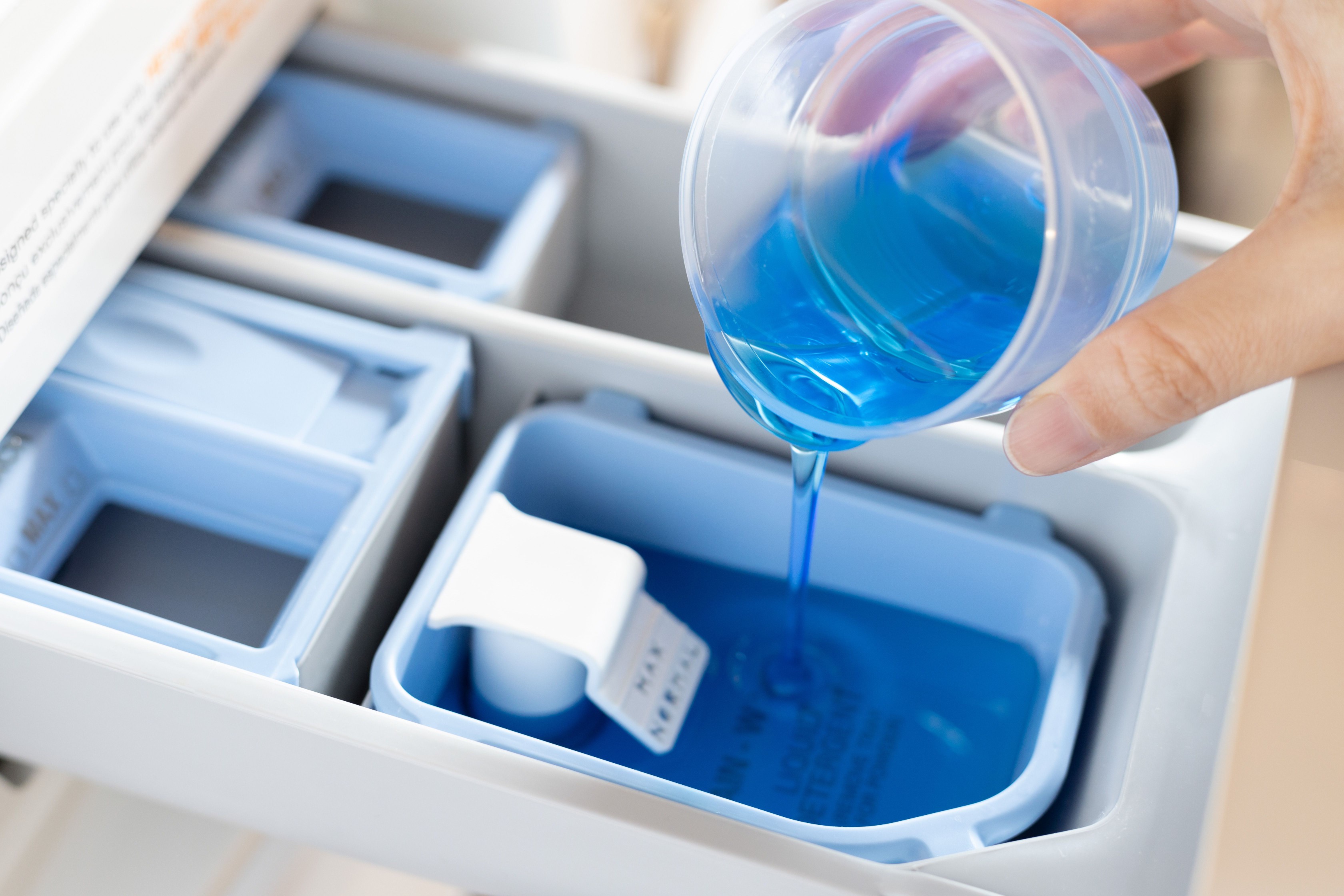 Enzyme-based detergent added to washer for laundering cat urine odor