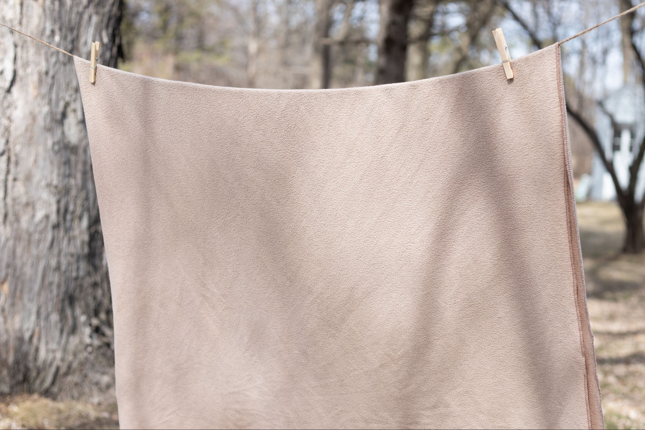 Tan bedding clipped on line wire to air dry outside