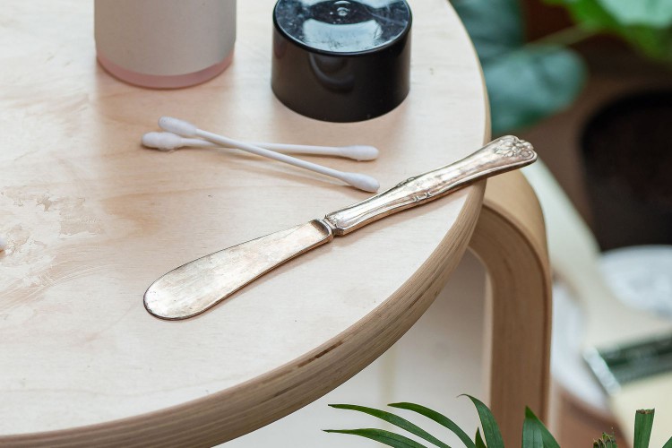 Use a butter knife to scrape excess glue off of a wooden table