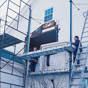 2 Men installing a second story bay window in a home.
