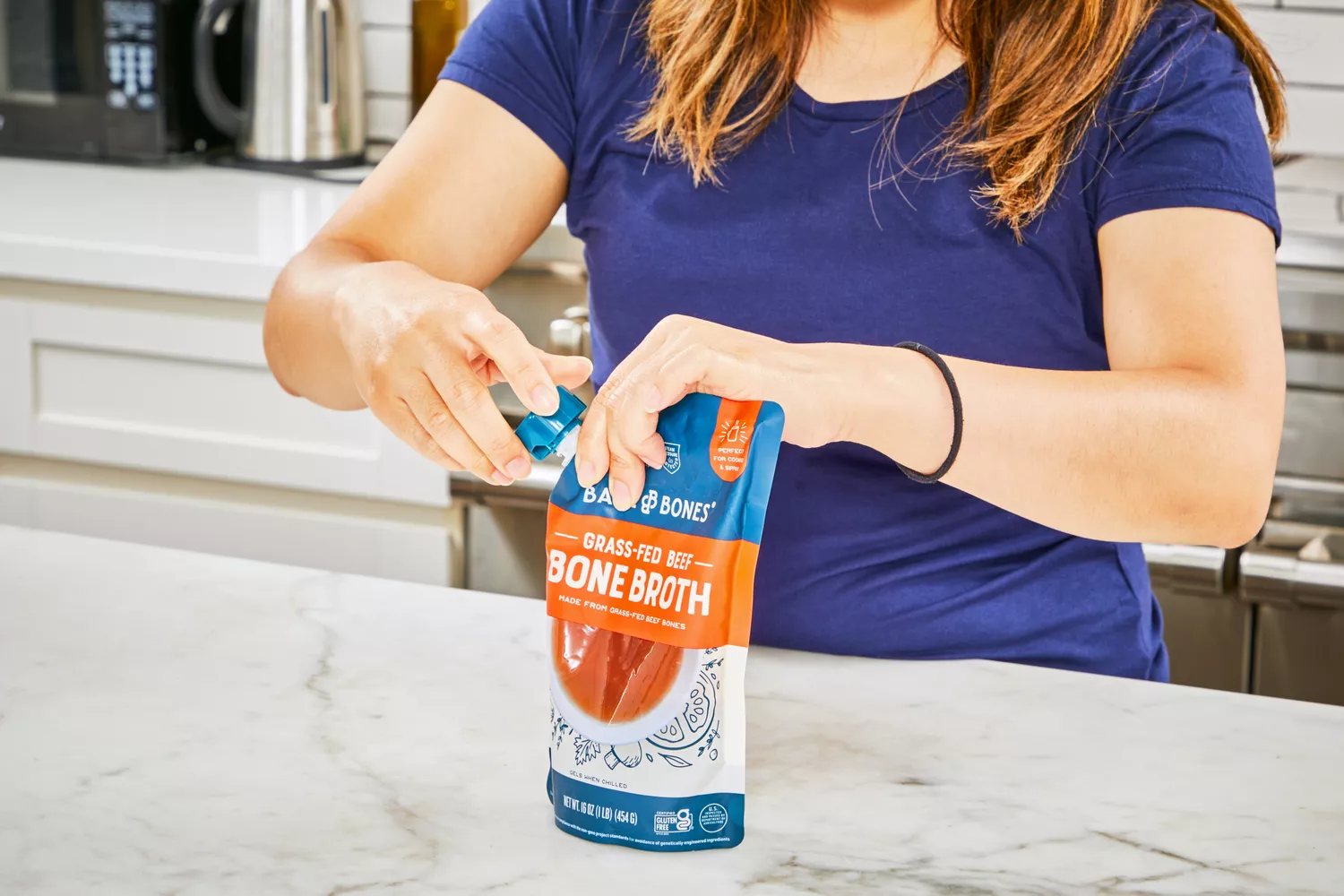 A person opens a bag of Bare Bones Grass-Fed Beef Organic Bone Broth