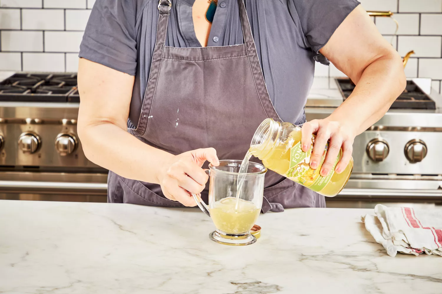 A person pours FOND Certified Organic Chicken Bone Broth into a glass