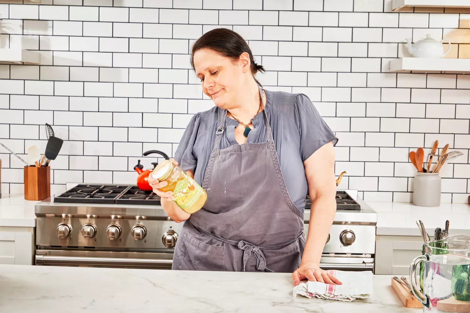 A person reads the label on the FOND Certified Organic Chicken Bone Broth jar