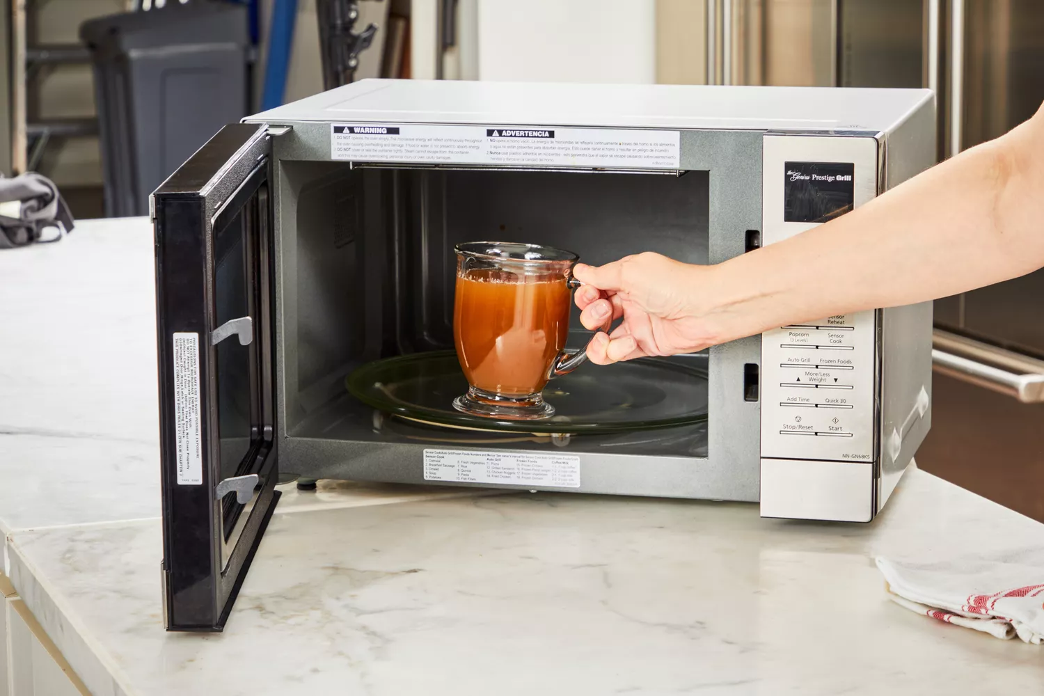 A glass of Kettle &amp; Fire Bone Broth is placed in a microwave