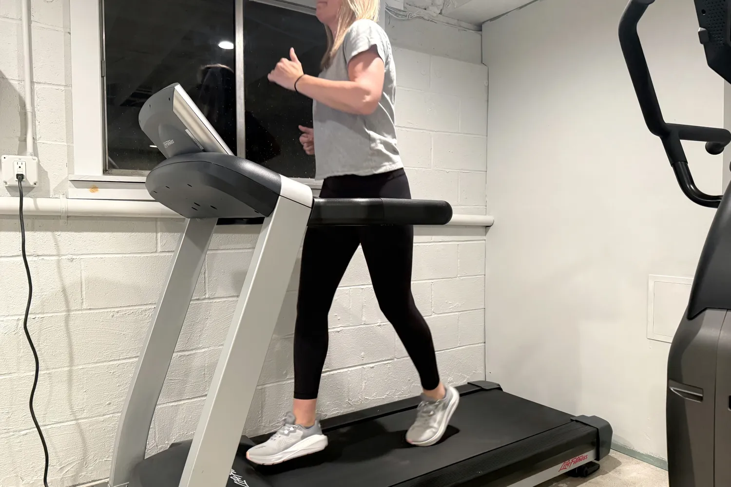 A person runs on a treadmill while wearing the Altra Women's Paradigm 8 Running Shoes