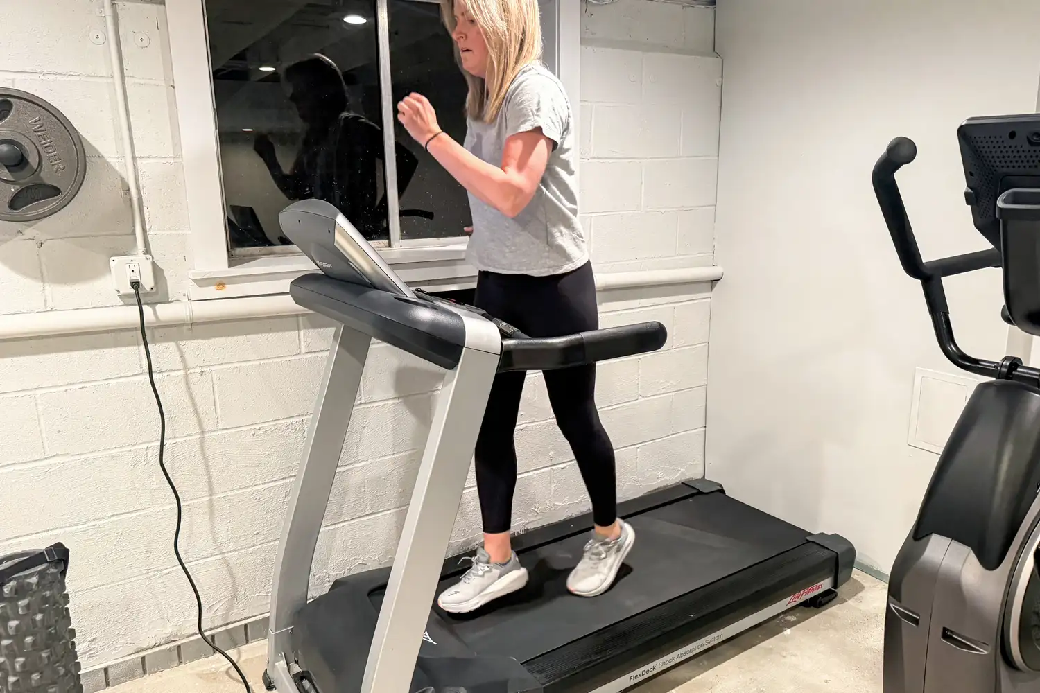 A person wears the Altra Women's Paradigm 8 Running Shoes while walking on a treadmill