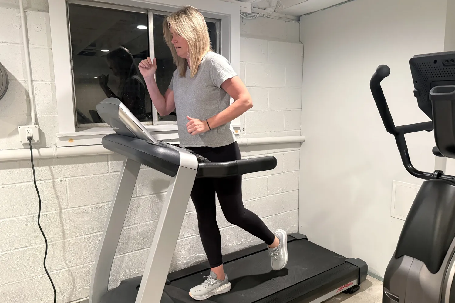 A person runs on a treadmill while wearing the Altra Women's Paradigm 8 Running Shoes