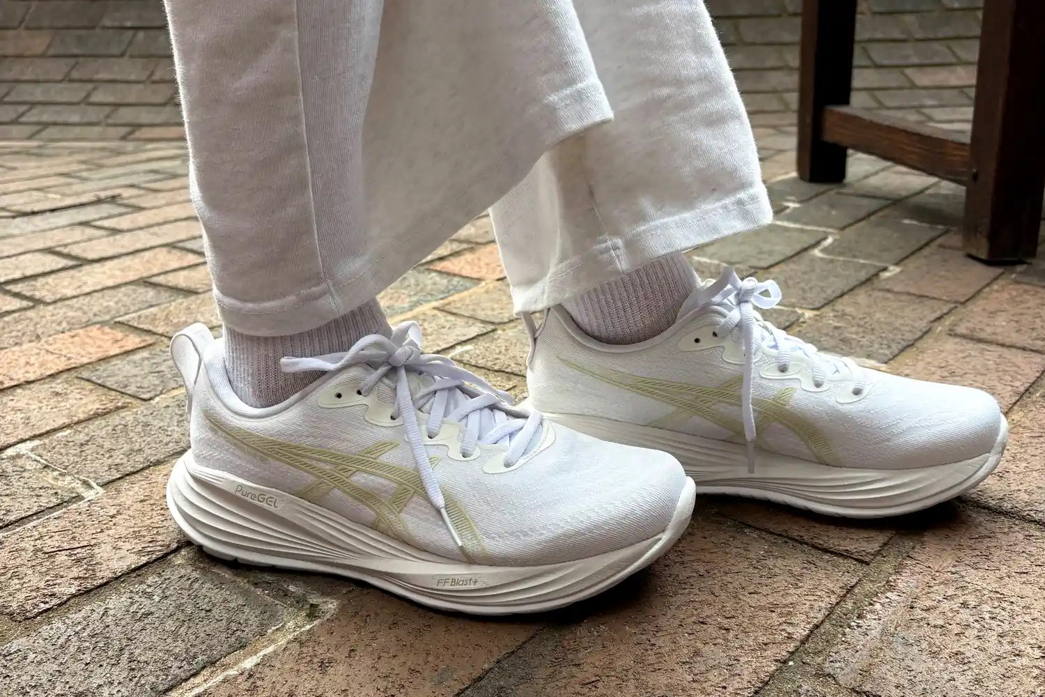 A side view of a person wearing the Asics Women's Gel-Cumulus 27 Running Shoes