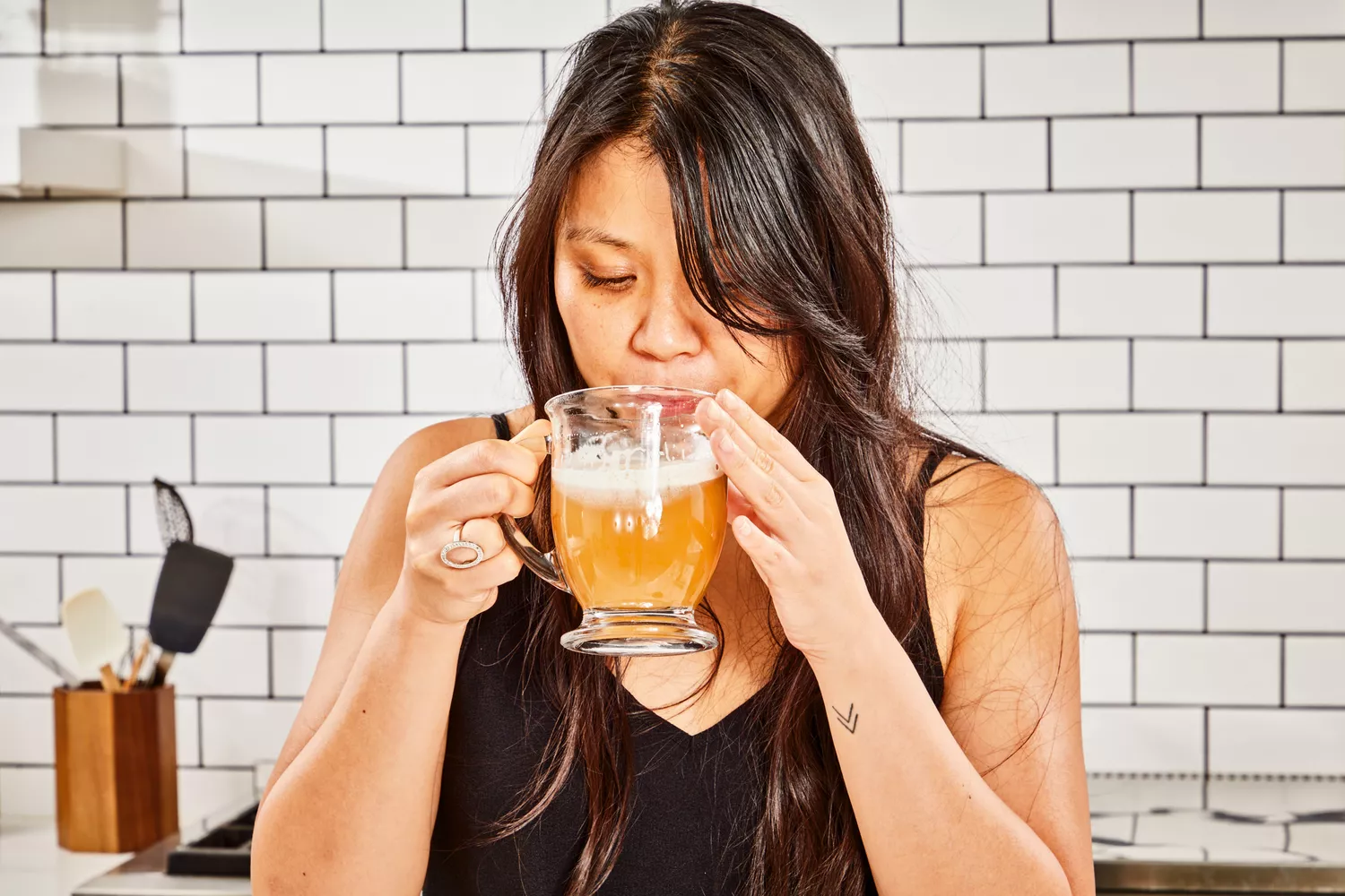 A person sips Ancient Nutrition Bone Broth Protein