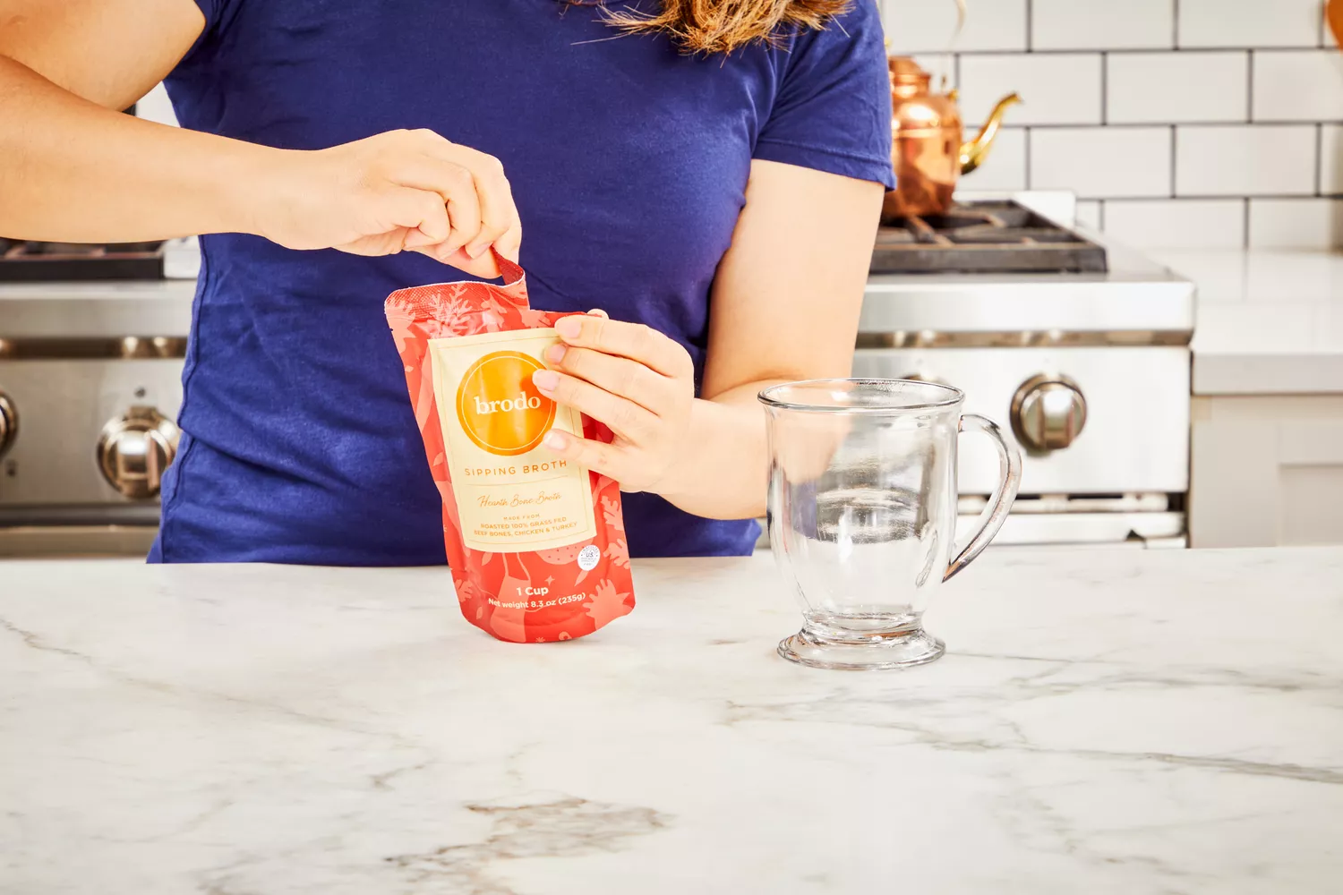 Person tearing package of Brodo Hearth Bone Broth